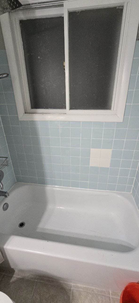 Blue bath wall tile repair area before bathroom remodeling by BAX