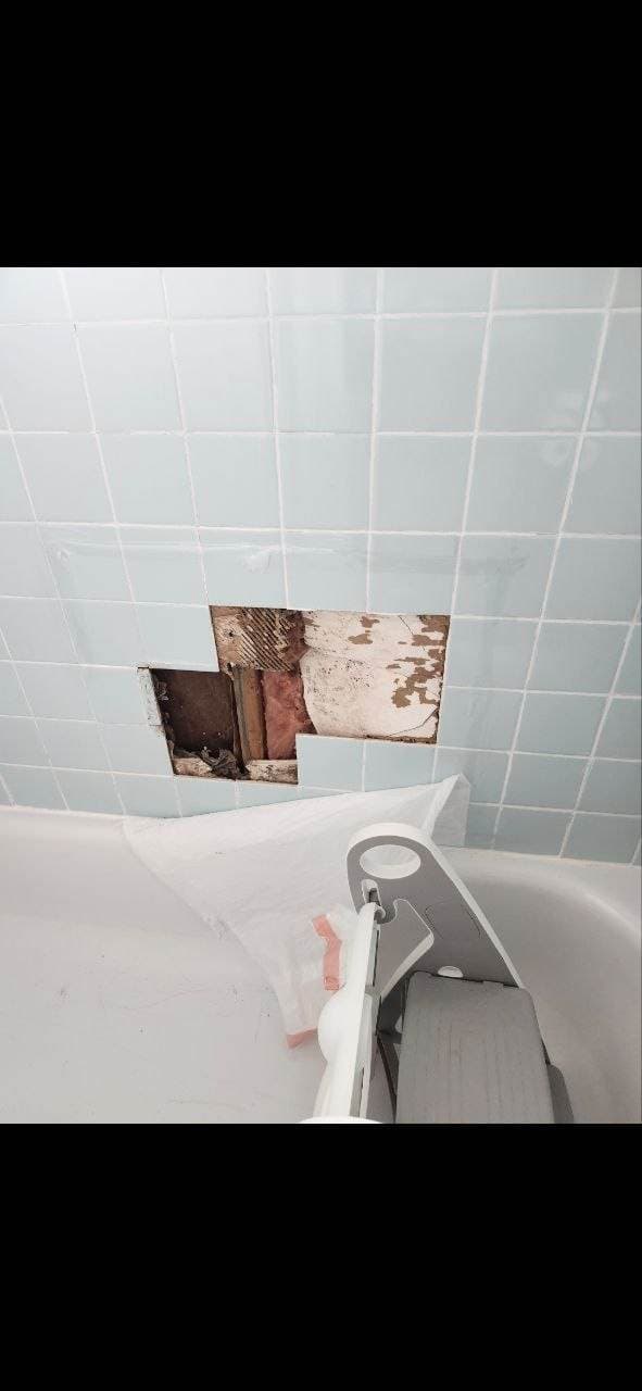 Open tub wall tile repair area before bathroom remodeling work by BAX