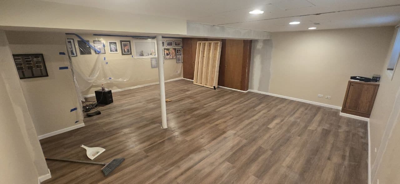 Finished basement laminate plank flooring installation by BAX